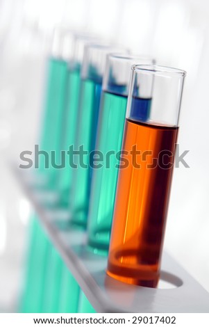 Laboratory glass test tubes filled with red liquid and green chemical solution on a rack for an experiment in a science research lab