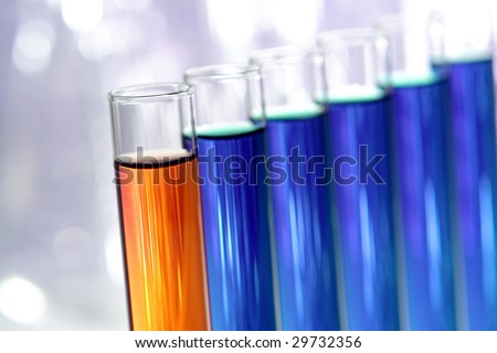 Laboratory glass test tubes filled with blue and orange liquid chemical for an experiment in a science research lab