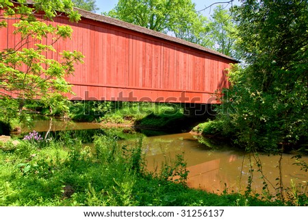 Traditional American wood covered bridge over a quiet creek in rural countryside