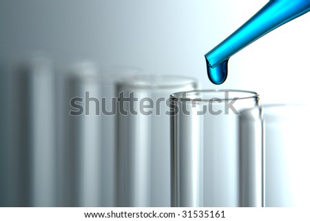 Laboratory pipette with drop of blue liquid chemical solution over empty glass test tubes for an experiment in a science research lab