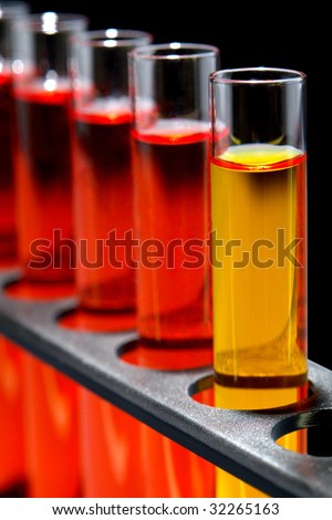 Laboratory glass test tubes filled with yellow and red liquid on a rack for an experiment in a science research lab