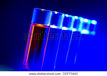 Laboratory glass test tubes filled with red and blue liquid on a rack for an experiment in a science research lab
