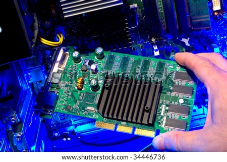 Computer technician hand holding a circuit board integrated card for repair or upgrade installation (all logos and trademarks markings and identification numbers have been removed)