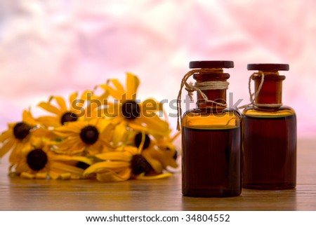 Traditional aromatherapy amber glass bottles filled with liquid scents essential oil fragrance and black eyed Susan flowers
