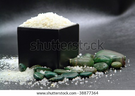 Natural bath soap sea salts in a black ceramic box with green decorative stones in a spa