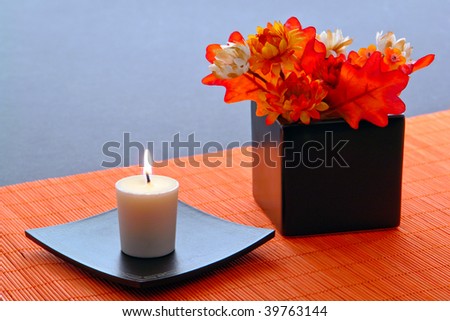 Aromatherapy candle burning in an Asian inspired motif with flowers