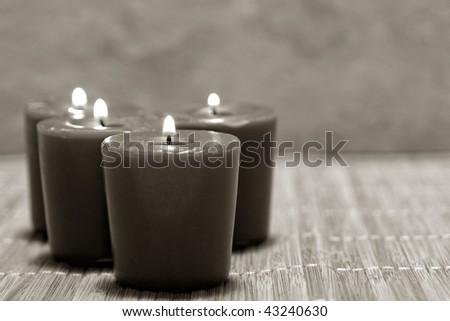 Meditation therapy votive candles burning with a soft glow on a bamboo mat