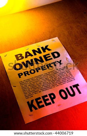 Grunge Real estate lender bank owned keep out sign notice posted on a boarded up foreclosed building in foreclosure (fictitious document with authentic legal language)