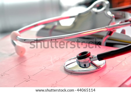 Medical doctor stethoscope over EKG graph result on a clipboard in a hospital emergency room