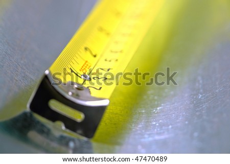 Self retracting construction tape measure with floating tang in inch and centimeter markings