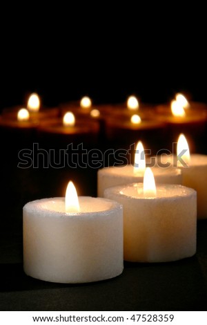 Prayer and meditation votive candles burning during a religious service in a dark church
