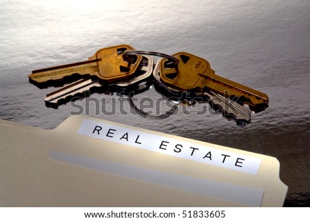 Printed real estate label on a manila office file folder with papers and set of house keys on a homeowner desk