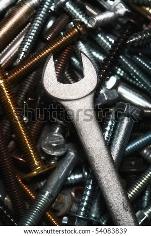 Open end wrench over pile of assorted bolts and lag screws