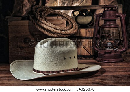 American West rodeo cowboy white straw hat with traditional ranch equipment and old ranching tools in a nostalgic Western barn