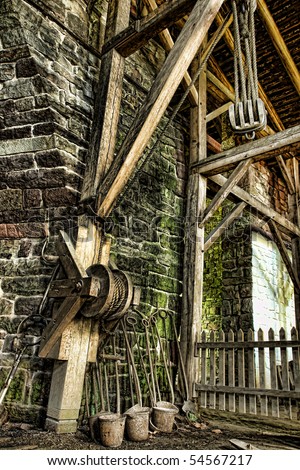 Antique treadwheel wood crane with compound pulley in an iron furnace inside a historic building at Hopewell Furnace National Historic Site in Pennsylvania