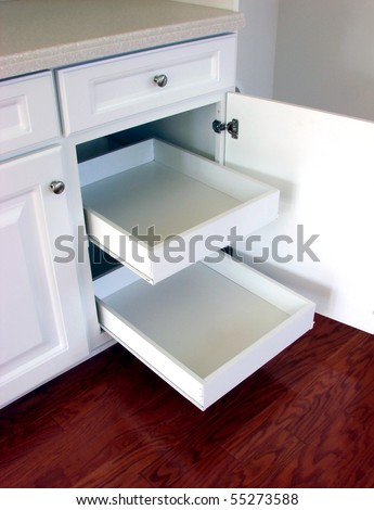 Pull out shelf drawers on white laminated cabinets in a contemporary American house kitchen