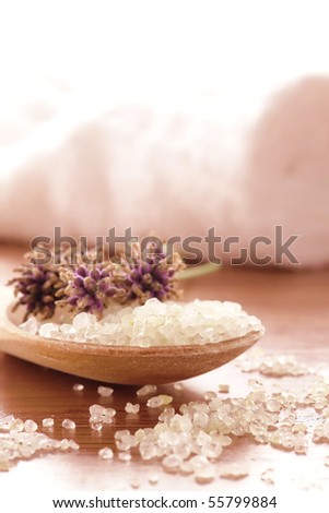 Natural sea bath salts in a wood spoon with fresh cut lavender flowers in a spa