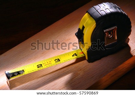 Self retracting construction tape measure on a wood board in a carpentry workshop