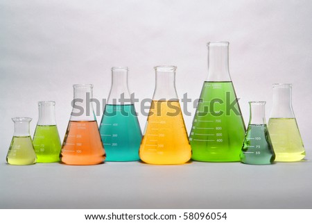 Laboratory glass conical Erlenmeyer flasks in a row filled with assorted colors liquid for an experiment in a science research lab