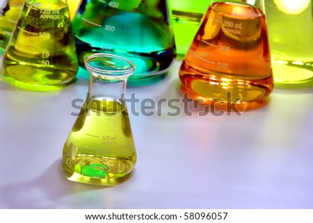Laboratory glass conical Erlenmeyer flasks filled with assorted colors liquid for an experiment in a science research lab