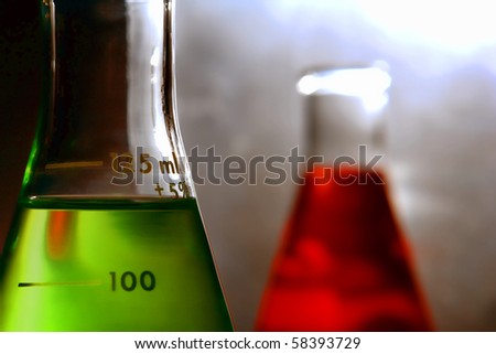 laboratory glass Erlenmeyer flasks filled with green liquid and red chemical solution for an experiment in a science research lab