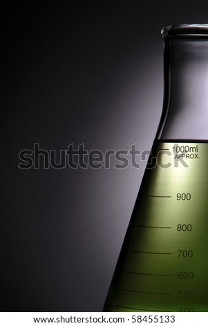 Laboratory glass conical Erlenmeyer flask filled with green liquid for an experiment in a science research lab