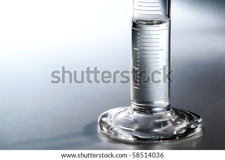 Laboratory glass scientific graduated cylinder detail filled with some clear liquid for an experiment in a science research lab