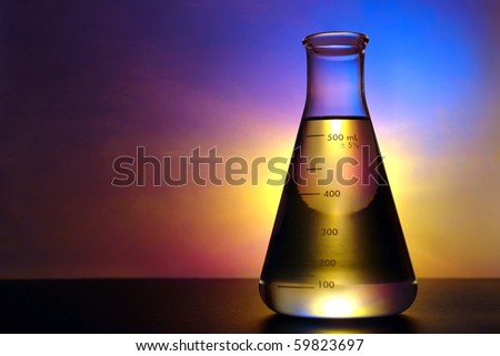 Laboratory glass conical Erlenmeyer flask filled with yellow liquid for an experiment in a science research lab