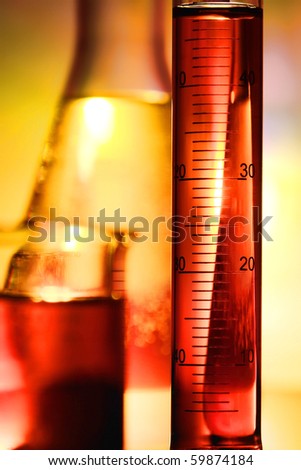 Laboratory glass scientific graduated cylinder filled with red liquid for an experiment in a science research lab