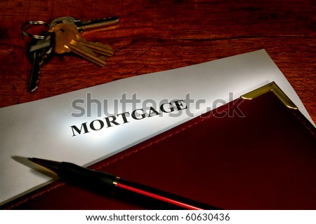 Real estate lending broker mortgage document in a leather binder with ink pen and set of house keys on a finance lender agent desk