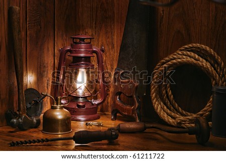 Antique craftsman carpentry wood workshop with vintage kerosene lamp burning and old carpenter hand tools