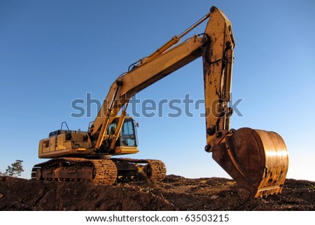 Heavy duty hydraulic crawler excavator on dirt field at a construction site