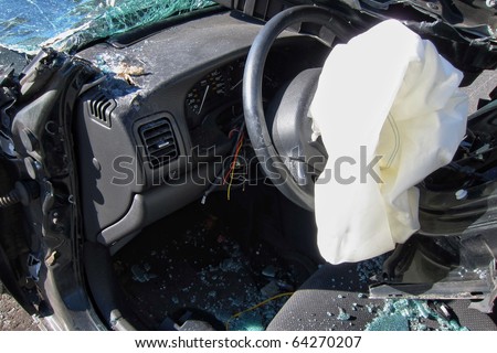 Deployed crash safety air bag in a heavily damaged wrecked car after a violent traffic accident