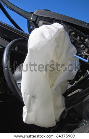 Deployed and deflated crash safety air bag in a heavily damaged wrecked car after a violent traffic accident
