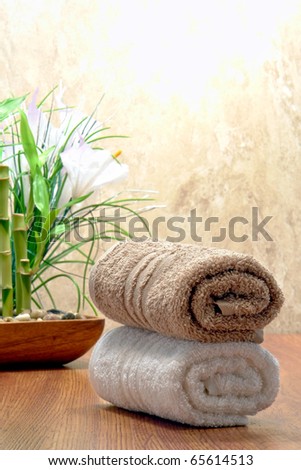 Fluffy soft cotton brown and white hand towels on wood surface in a spa