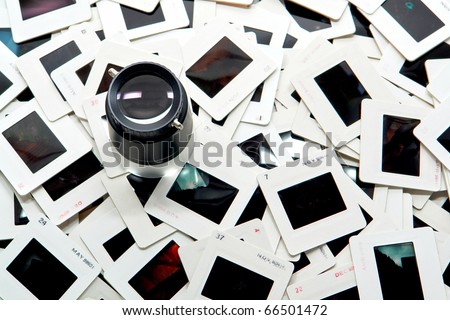 Photo editing magnifier loupe over stack of old transparency film slides in cardboard mount for a quality inspection (copyright holder and author is photographer)