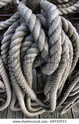 Thick ship sail rigging twisted natural fiber rope coiled on a deck