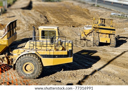 Wheel tractor articulated dirt hauler and bulldozer heavy duty earth moving equipment on road construction site