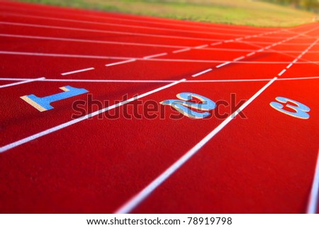 One two and three lane numbers on a field running race track in a athletic stadium
