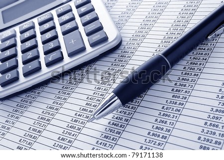 Ballpoint ink pen and calculator on a financial spreadsheet statement with columns of numbers for an accounting budget finance reconciliation