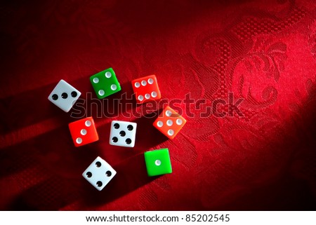 Gambling craps game dice used for shooting and rolling with bet wager on roll over luxurious red damask fabric in a classy casino