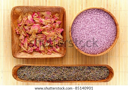 Aromatherapy natural ingredients of lavender seeds and scented dried flower petals with aromatic bath soap salts in wood bowls for a pampering and soothing body care relaxation session in a spa