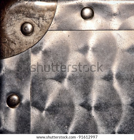 Engine turned finish type steel sheet metal grunge background with reinforcement corner and solid rivets featuring old scratches and dents on a container case