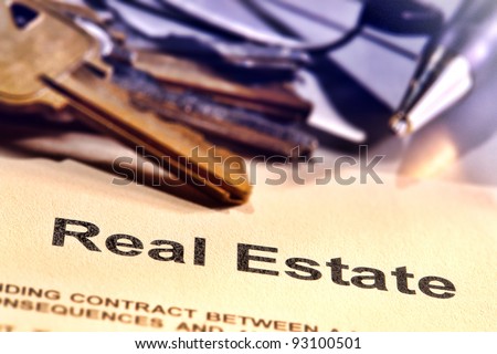 Title word real estate on a Realtor broker document contract page with set of house keys and ink pen in a realty brokerage resale office (fictitious document with authentic legal language)