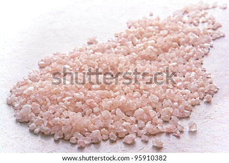 Pink aromatherapy scented and fragrant bath soap salts spill on bathroom stone tile