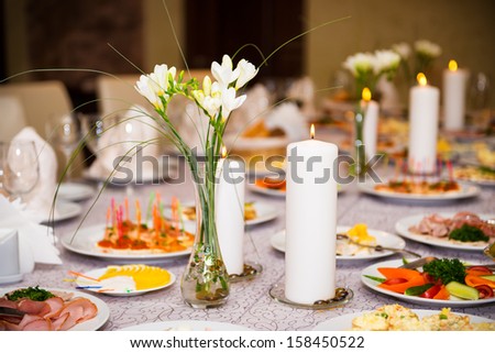 Table served with a meal in a restaurant with candles and flowers