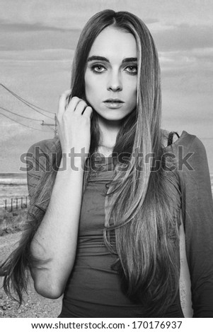 Vintage black and white portrait of beautiful lonely woman standing on the road