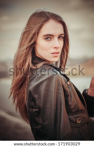 Portrait of beautiful woman in leather coat outdoors
