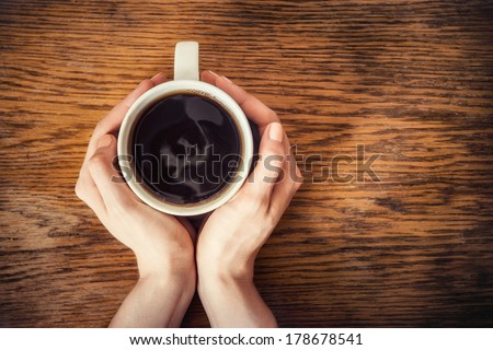 Woman Hands Holding Mug Of Hot Drink That Standing On Wooden Table