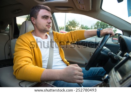 Man driving luxury car. Concept photo of safety driving with seat belt.